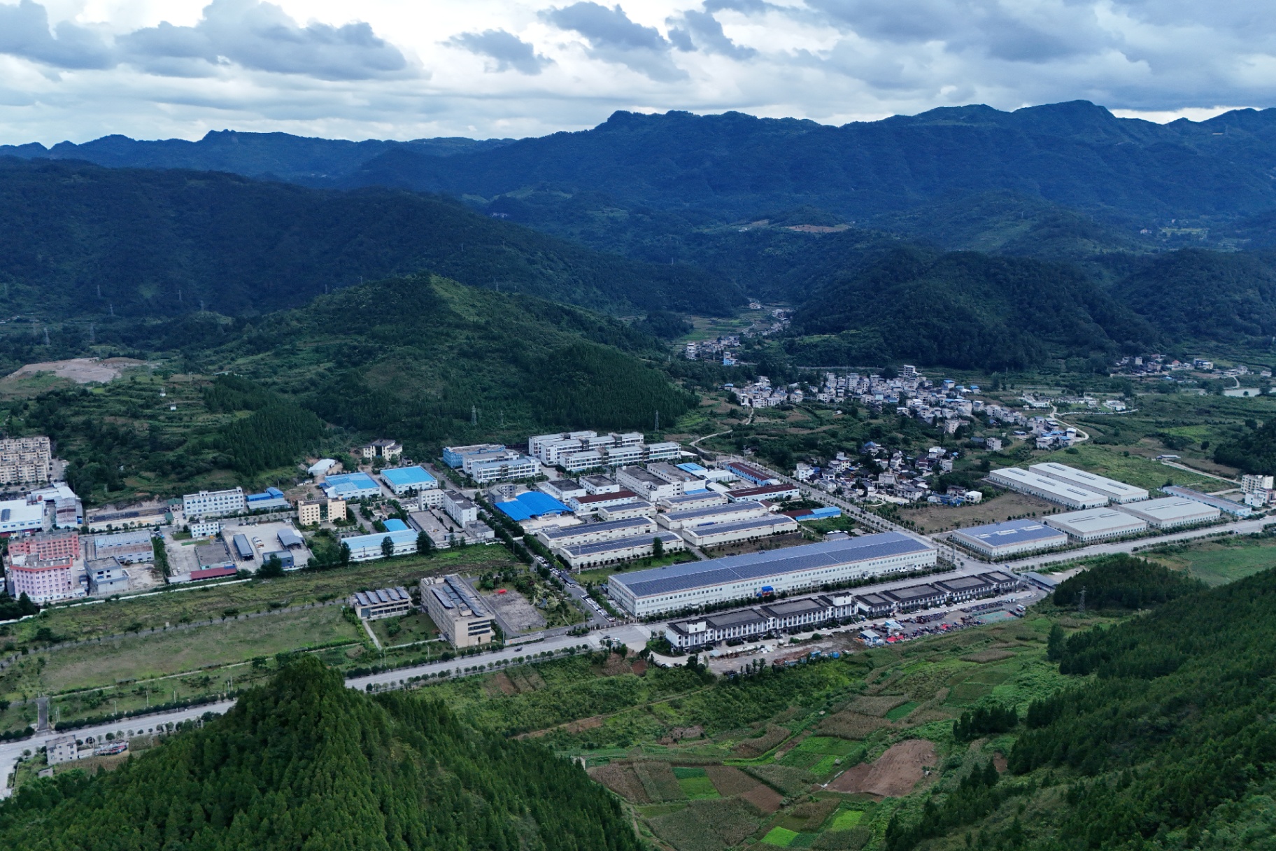 Aerial view of the GUI TEA matcha super factory in Tongren, Guizhou — surrounded by mountain villages and highland tea country